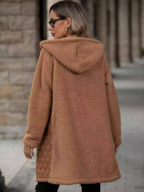 Person wearing a brown teddy coat with a hood in an urban setting.