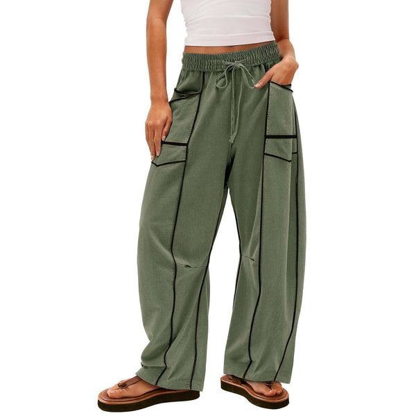 Green wide-leg pants with black piping worn by a person on a white background