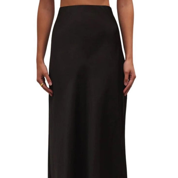 Front view of model wearing Europa Poly Sheen Skirt in black. shows the high sit. also so the sheen of the skirt. 