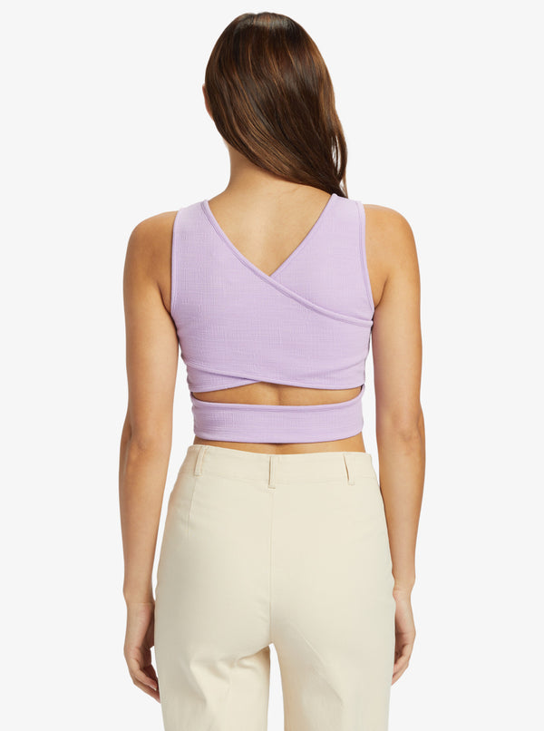 back view of the model wearing the good keepsake crop top. shows the deep back v neckline. also shows the cross back design, the wide straps and the cropped length. 