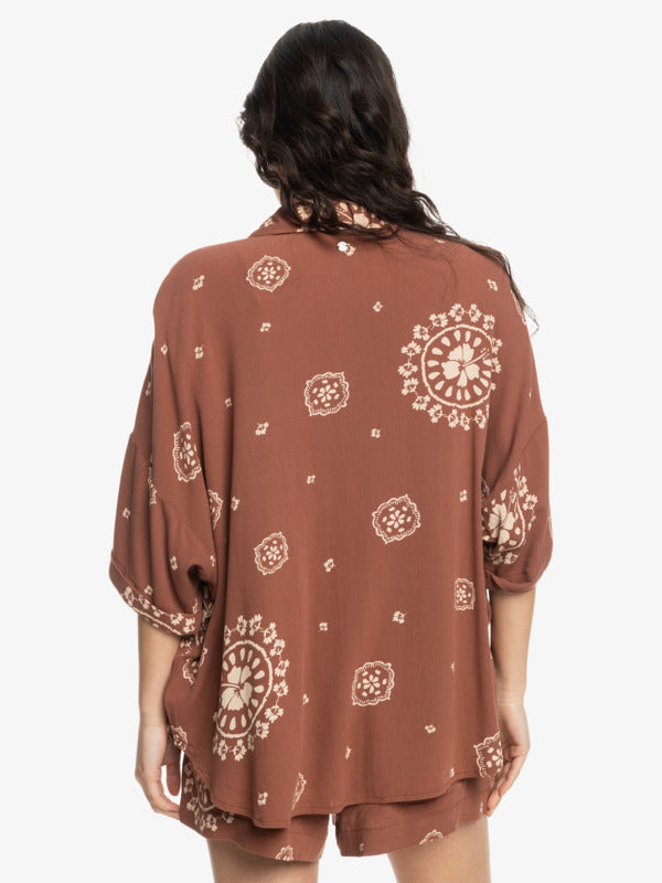 back view of the model wearing the beach nostalgia woven shirt. shows the fun pattern. also shows the dropped shoulders, the cuff at the bottom of the sleeves and the oversized fit. 