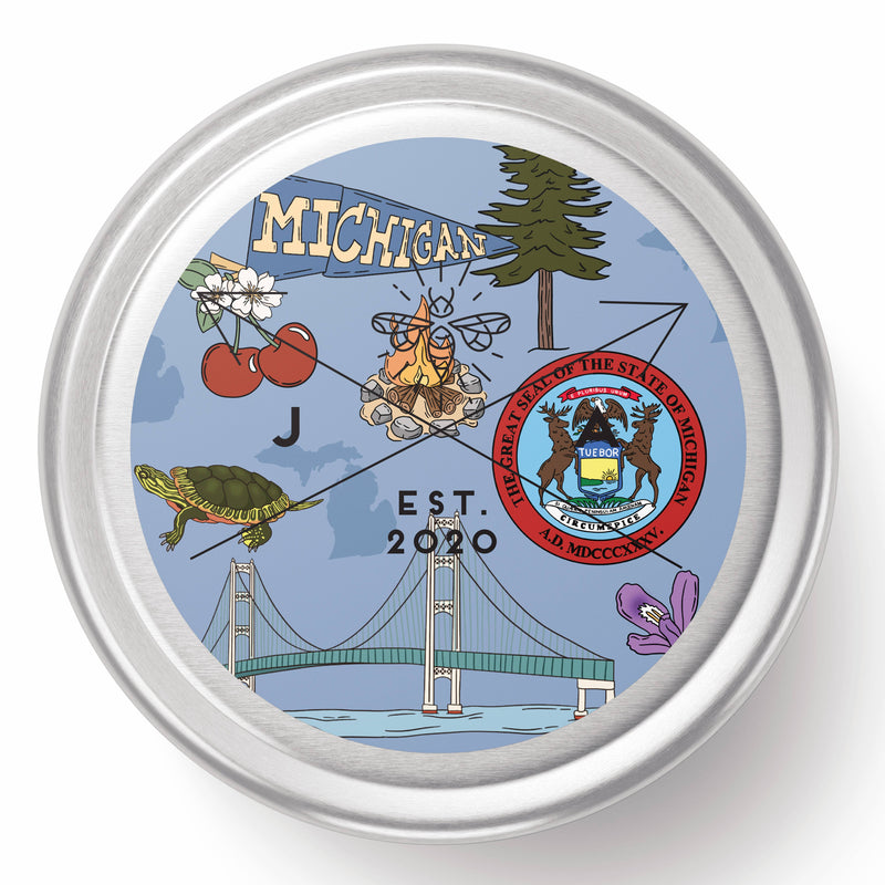 Round decorative item with Michigan-themed design including a bridge, tree, and other elements on a blue background.