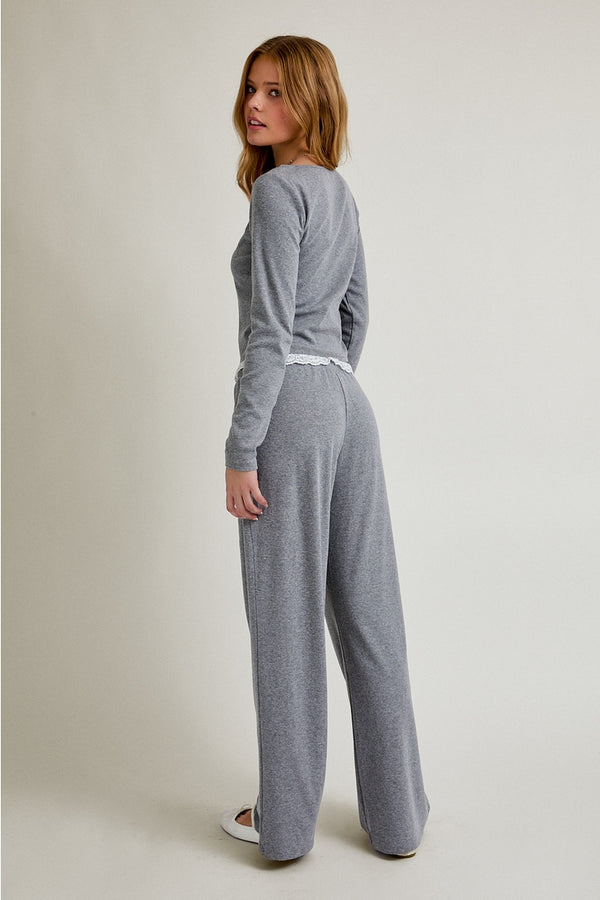 Woman wearing a gray loungewear set on a plain background