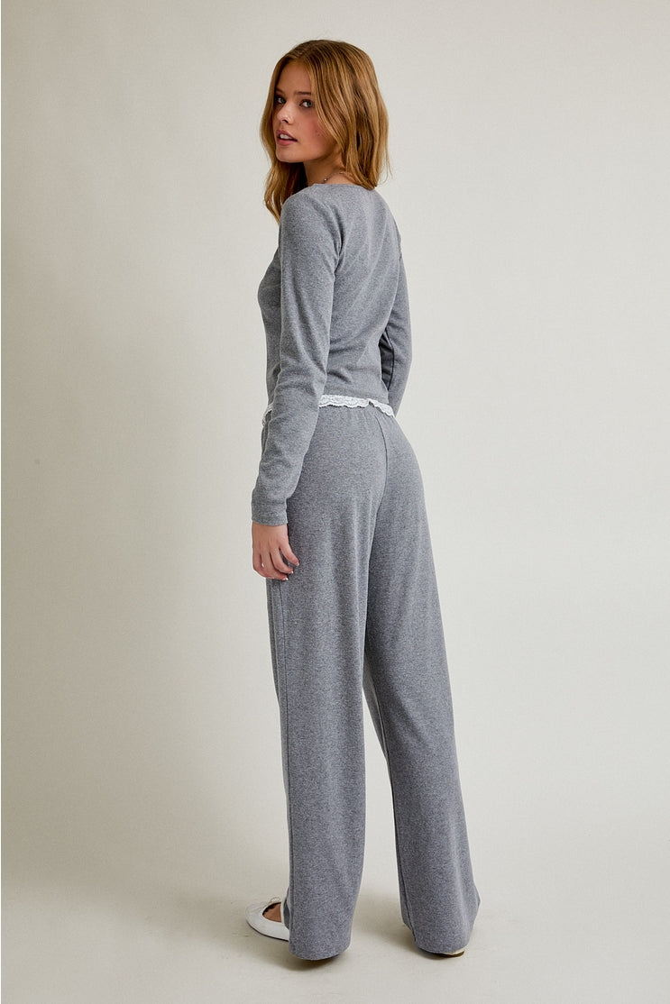 Woman wearing a gray loungewear set on a plain background