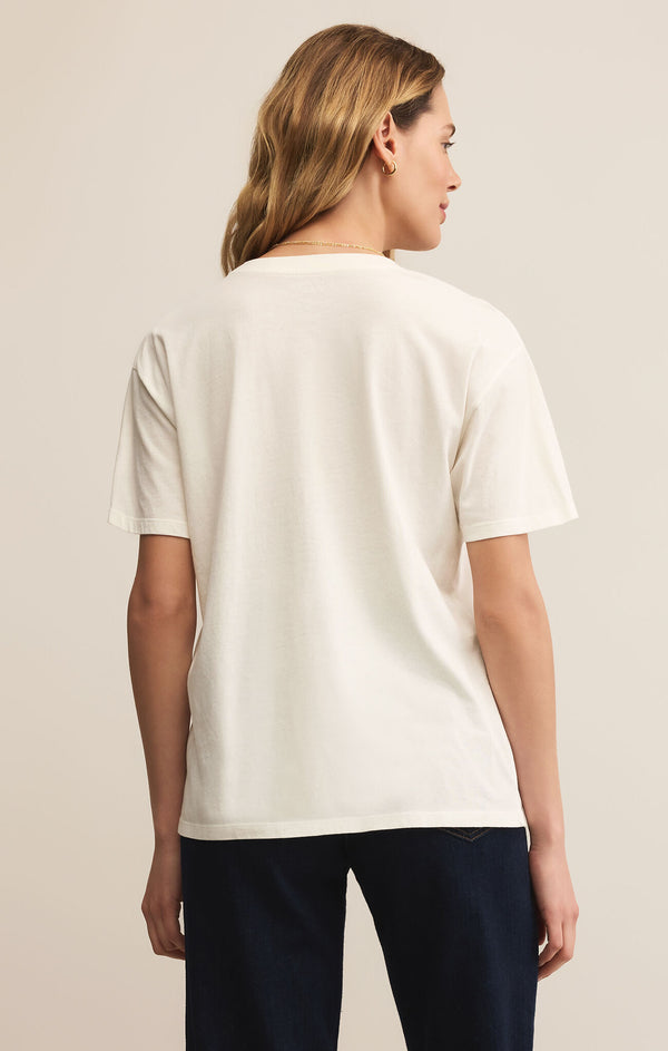 Person wearing a white t-shirt and dark pants on a plain background