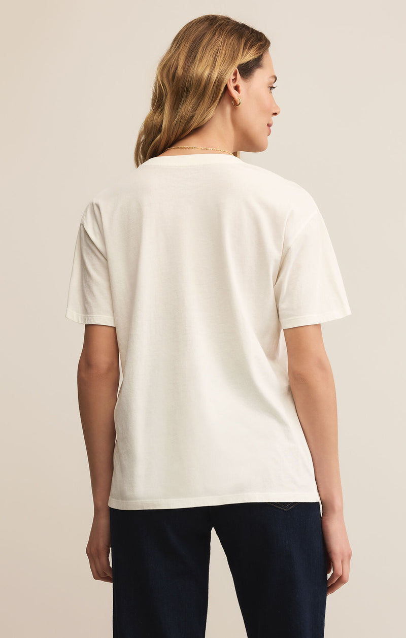Person wearing a white t-shirt and dark pants on a plain background