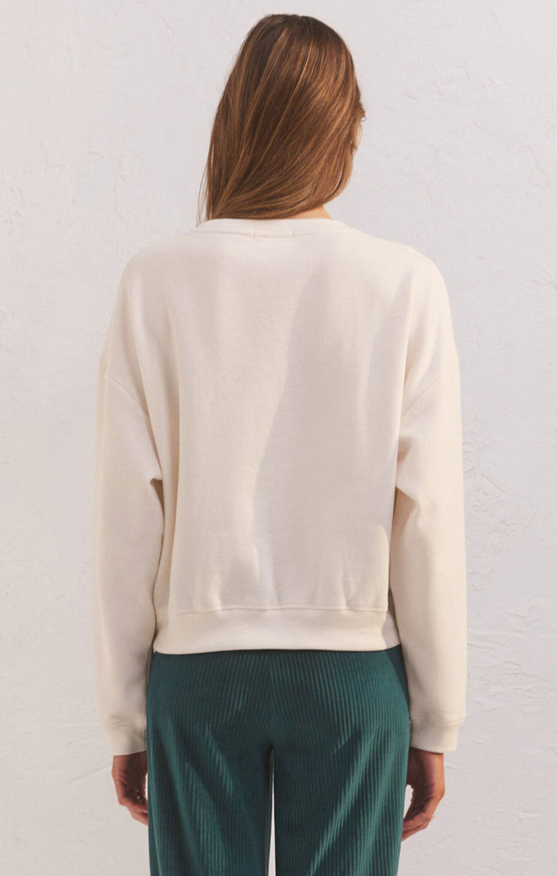 Back view of model wearing top. Shows the relaxed fit. also shows the crew neckline and the bone color.
