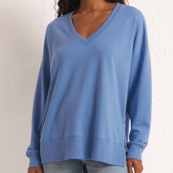front view of the model wearing the modern v neck weekender. shows the ribbed v neckline. also shows the oversized fit, the side slits and the dropped shoulders. 