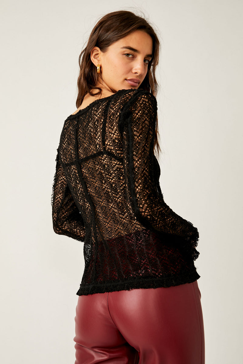 Back view of model wearing the on the road twisted tee. Shows the defined hems. Also shows the sheer knit fabric. 