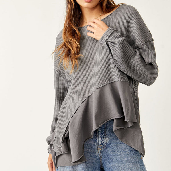 Front view of model wearing vada thermal. Shows the asymmetrical bottom hem. Also shows the waffle knit fabric & the scoop neckline. 