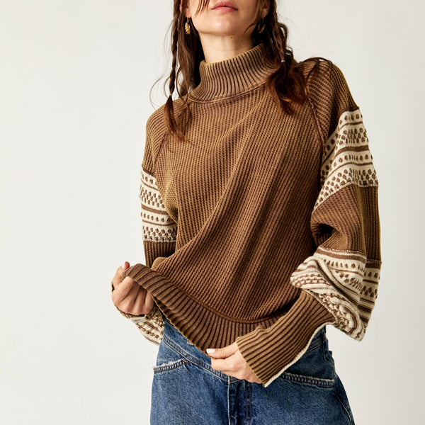 front view of model wearing the get cozy swit in hot fudge. shows the mock neckline. also shows the ribbed bottom hem and cuffs, the cream detailing throughout, the slouchy, relaxed fit and the tight cuffs.
