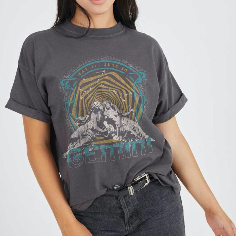 Front view of model wearing tee. Shows the crew neckline. Also shows the cuff sleeves, distressing on neckline and the gemini zodiac graphic. 