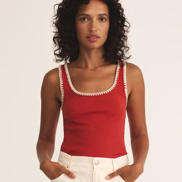 front view of the model wearing the jaidynn rib tank. shows the red color. also shows the scoop neckline, the ribbed detailing, the cream stitching around the neckline and armholes. 