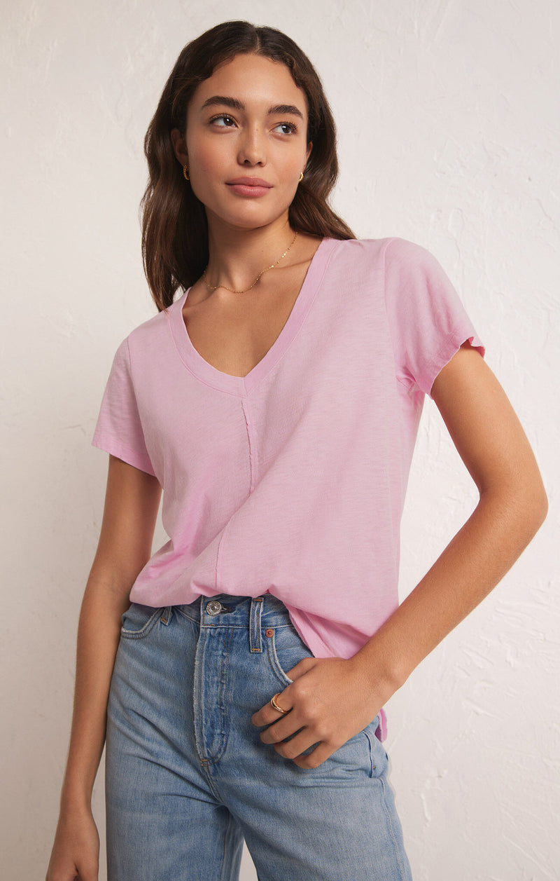 front view of the model wearing the asher v neck tee. shows the relaxed fit. also shows the v neckline, the curved raw hem and the raw seams detailing. 