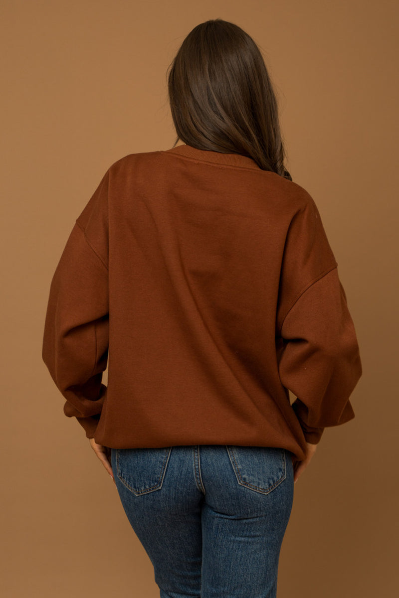 back view of the Helen good energy club sweatshirt in brown. shows the crew neckline. also shows the drop shoulders and the oversized fit. 