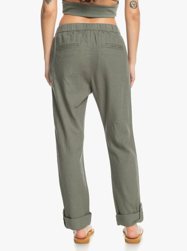back view of the model wearing the on the shore cargo pants in  agave green. shows the straight fit. also shows the rollable bottoms cuffs and the synched waist. 
