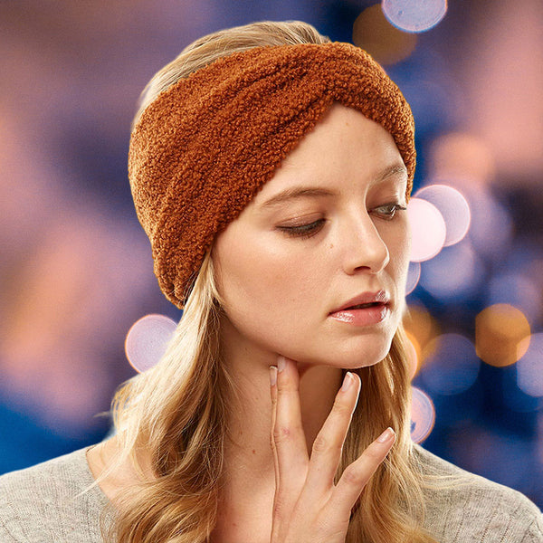 front view of model wearing earmuff headband. Shows the front tie knot detail and the sherpa fleece material in this brown color.  