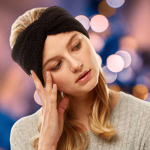 front view of model wearing earmuff headband. Shows the front tie knot detail and the sherpa fleece material in this black color.