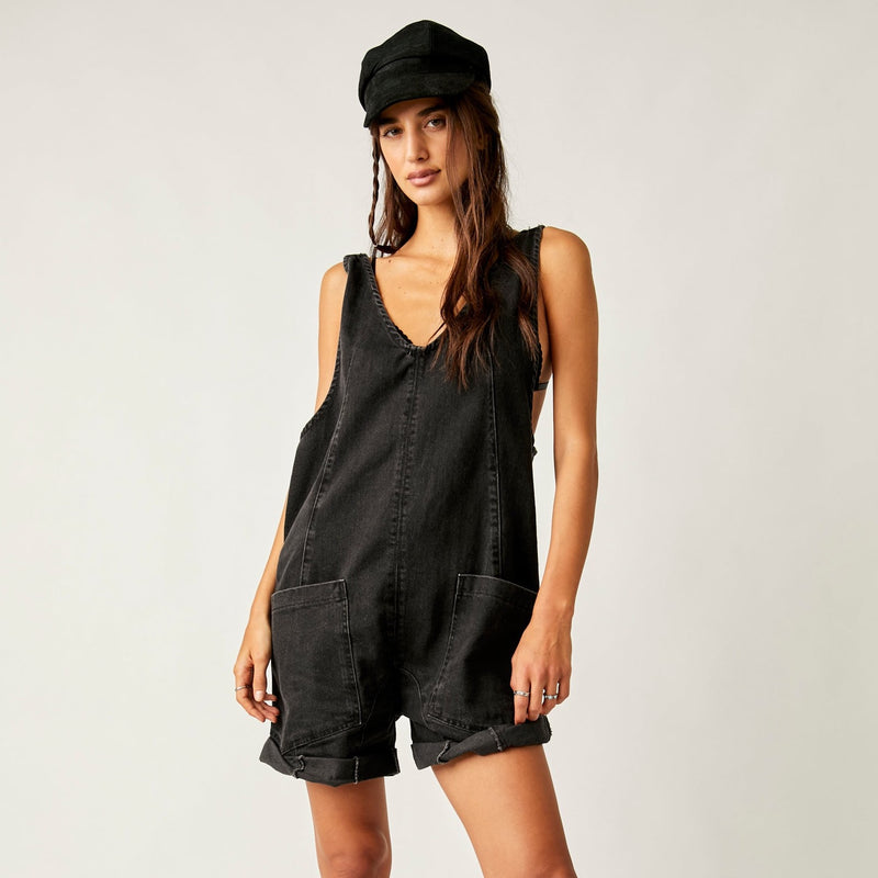 front view of the model wearing the high roller shortall in true north. shows the deep v neckline. also shows the slouchy, relaxed fit, the two front patch pockets and seam detail throughout. 