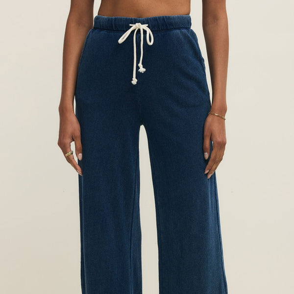 Navy blue pants with a drawstring on a neutral background