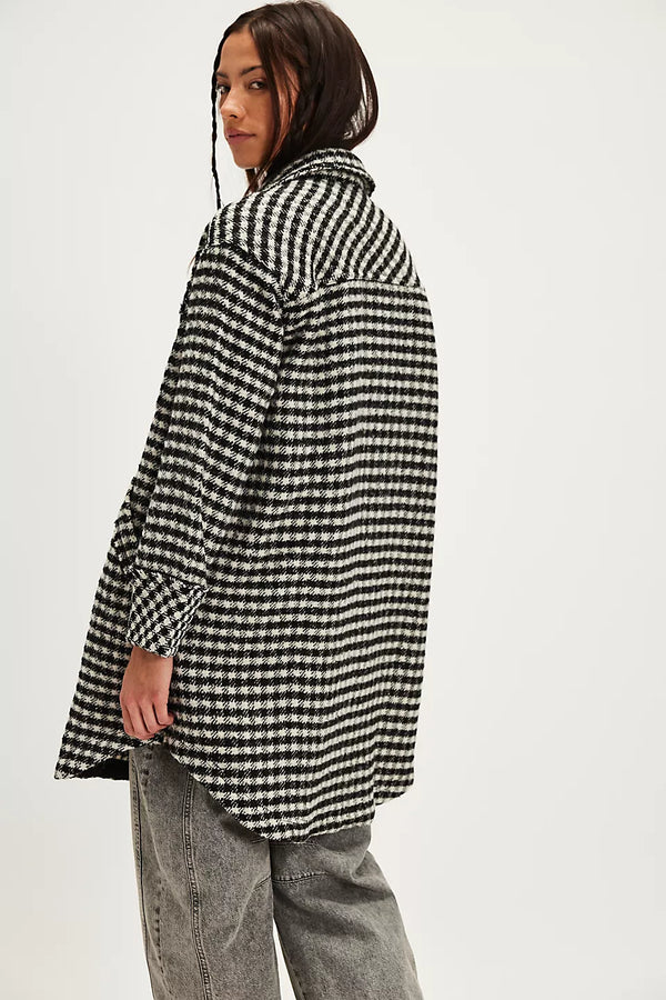 Person wearing a black and white checkered coat on a white background