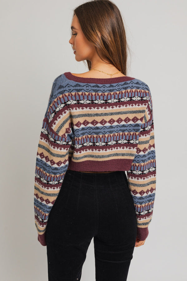 back view of model wearing the ellie cropped sweater in plum multi. shows the drop shoulders. also shows the crop length, the beautiful vintage pattern and the ribbing on the hems and cuffs. 