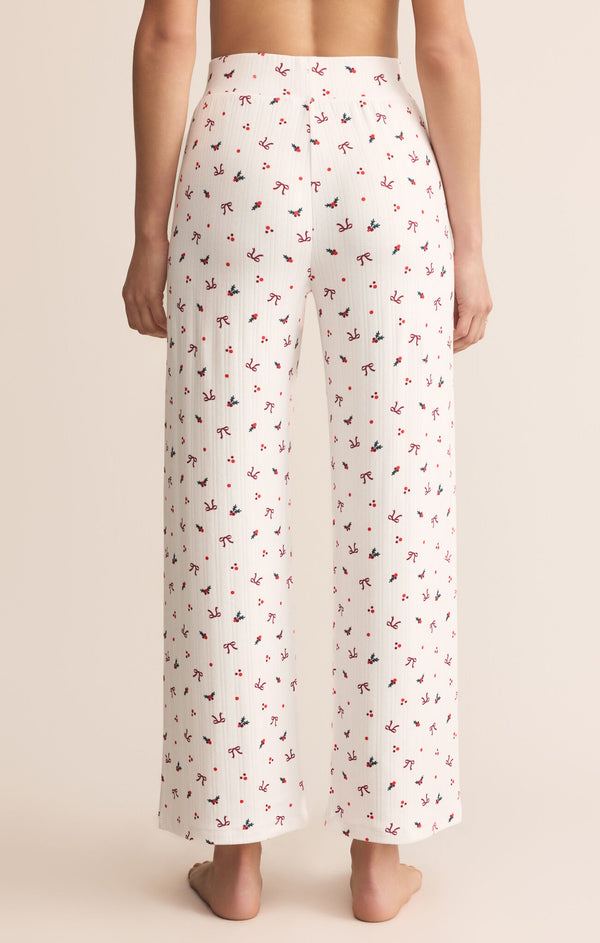 White pajama pants with a subtle pattern worn by a person on a beige background