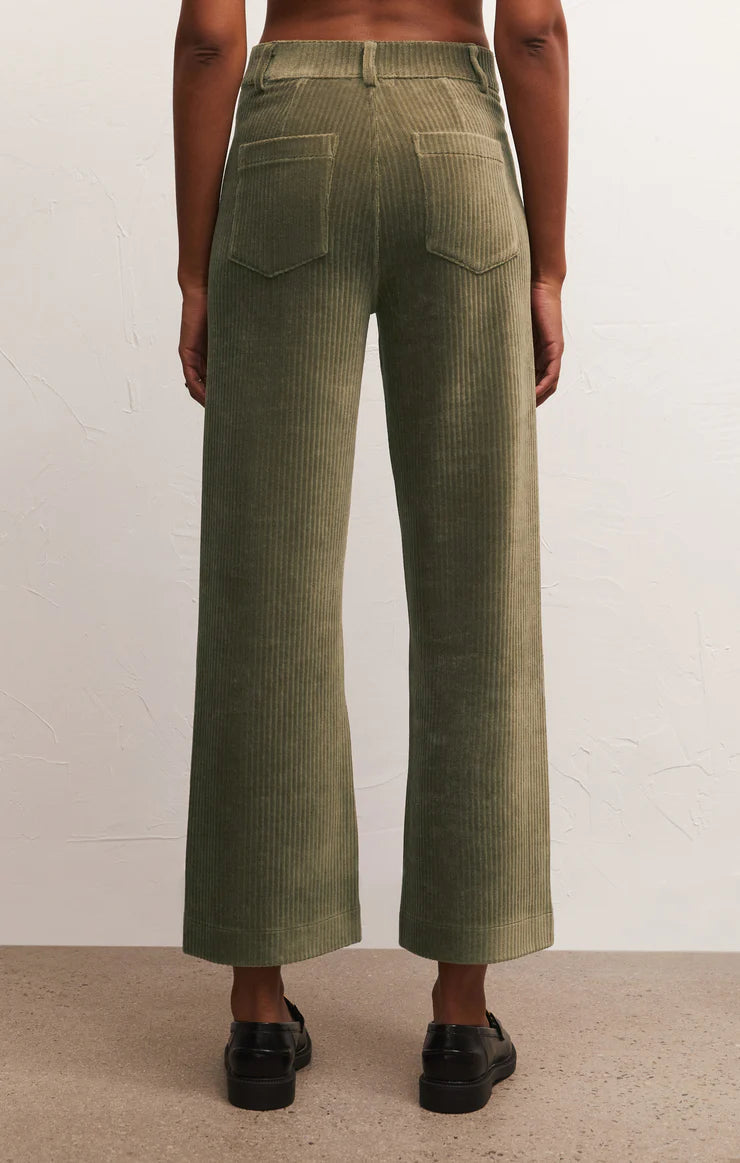 back view of model wearing prospect knit cords in kelp. shows the back patch pockets. also shows the wide flare legs, belts loops and the defined seams above the patch pockets. 