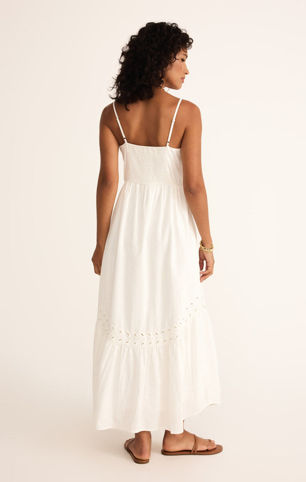 back view of the model wearing the citadelle maxi dress. shows the adjustable straps. also shows the bottom ruffle, the eyelet detailing, and the smocked back. 