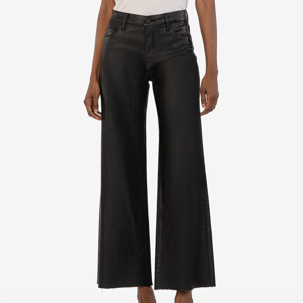 Front view of model wearing pants. Shows the high rise. Also shows the coating, the wide leg and the black color of the pants. 