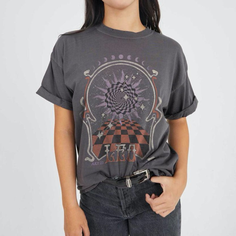 Front view of model wearing tee. Shows the crew neckline. Also shows the cuff sleeves, distressing on neckline and the Leo zodiac graphic. 