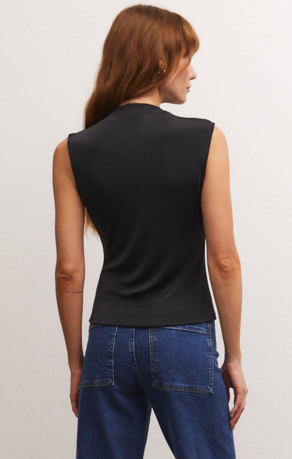 back view of the model wearing the libra shine jersey top in black. shows that the top is sleeveless. also shows that the top is about hip length on model, shows the faux mock neck. 