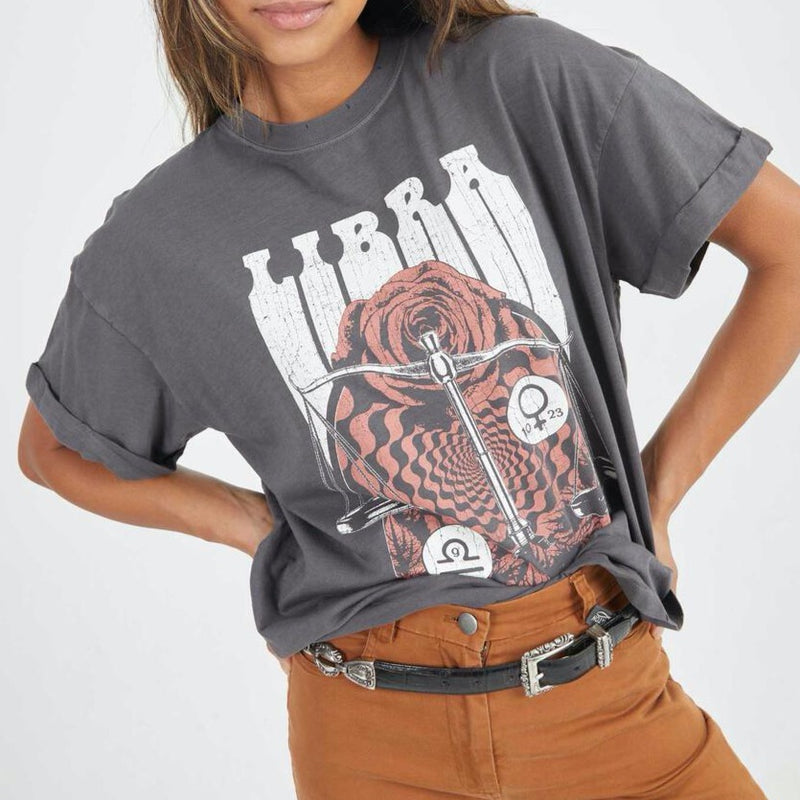 Front view of model wearing tee. Shows the crew neckline. Also shows the cuff sleeves, distressing on neckline and the libra zodiac graphic. 