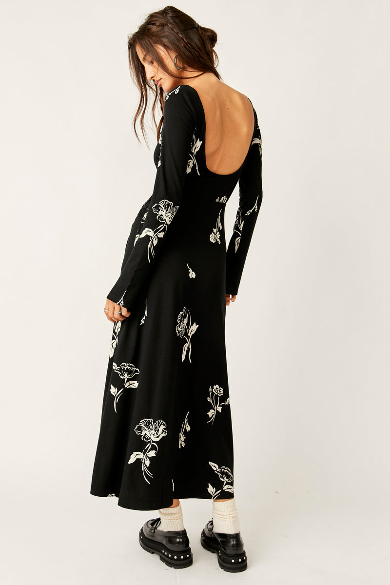 back view of the model wearing the love and b beloved midi. shows the low scoop back. also shows the midi length, the long sleeves and the all over floral detailing. 