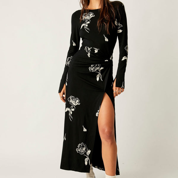 front view of the model wearing the love and be loved midi. shows the high front slit. also shows the slit hem on the sleeves, the knotted detail on the waist and the boat neckline.