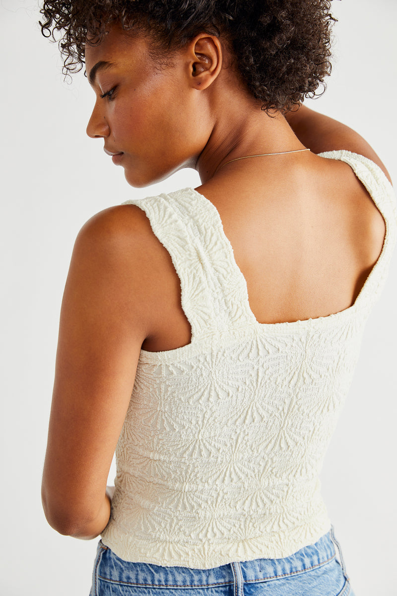 back view of the model wearing the love letter cami in ivory. shows the lettuce edge hemline. also shows the wide, scalloped straps and the square neckline.