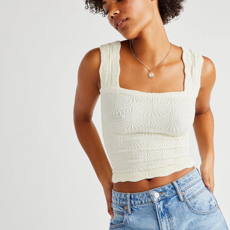 front view of the model wearing the love letter cami in ivory. shows the wide, scalloped straps. also shows the square neckline and the lettuce edge hemline.