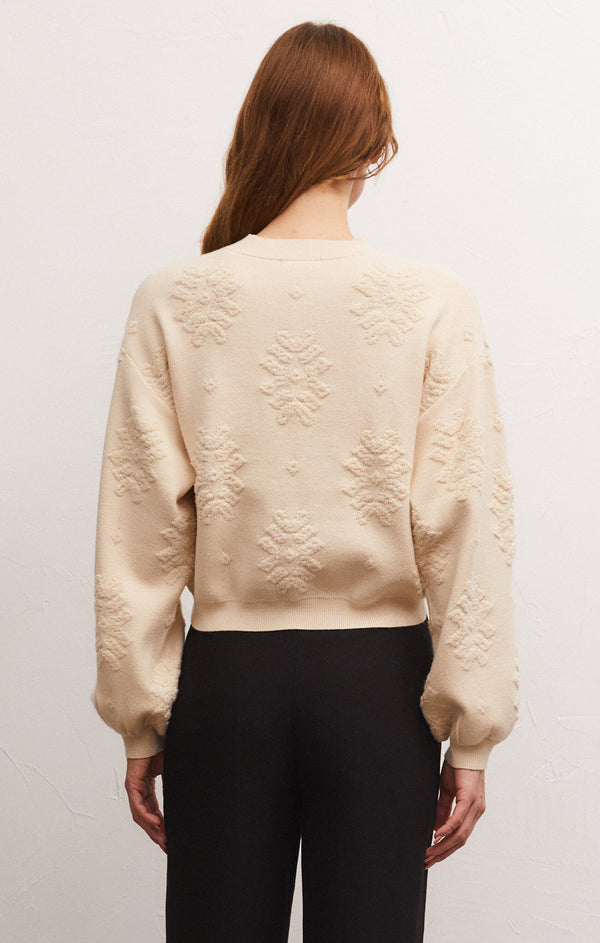 back view of the Malin sweater top. shows the blouson sleeves. also shows the textured print throughout, the drop shoulders and the waist length.
