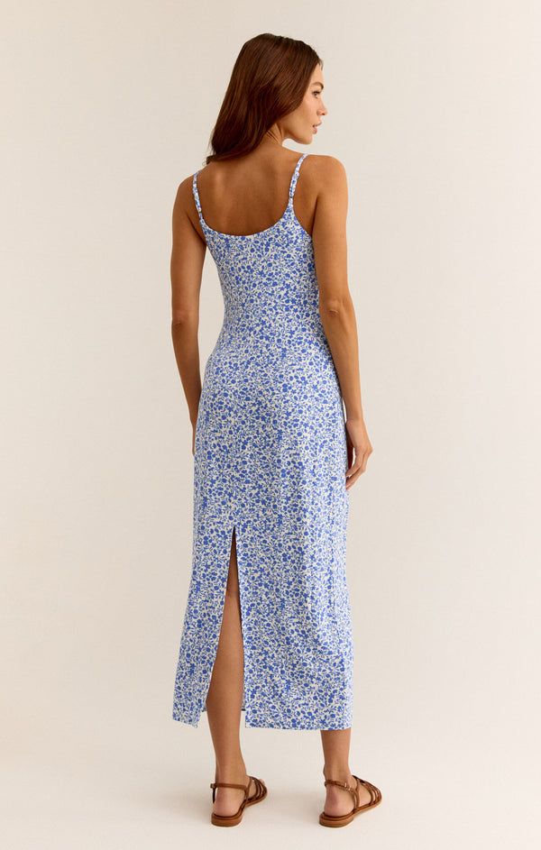 back view of the model wearing the carita cocos floral midi dress. shows the back slit. also shows the spaghetti straps and the low back scoop neckline. 