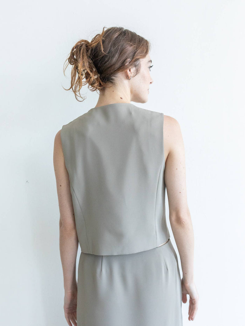 Back view of model wearing the vest. Shows two defined seams. Also shows the waist length and the beautiful khaki color. 