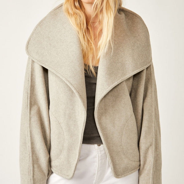 Front view of model wearing jacket. Shows the exaggerated collar.  Also shows the relaxed fit and side pockets. 