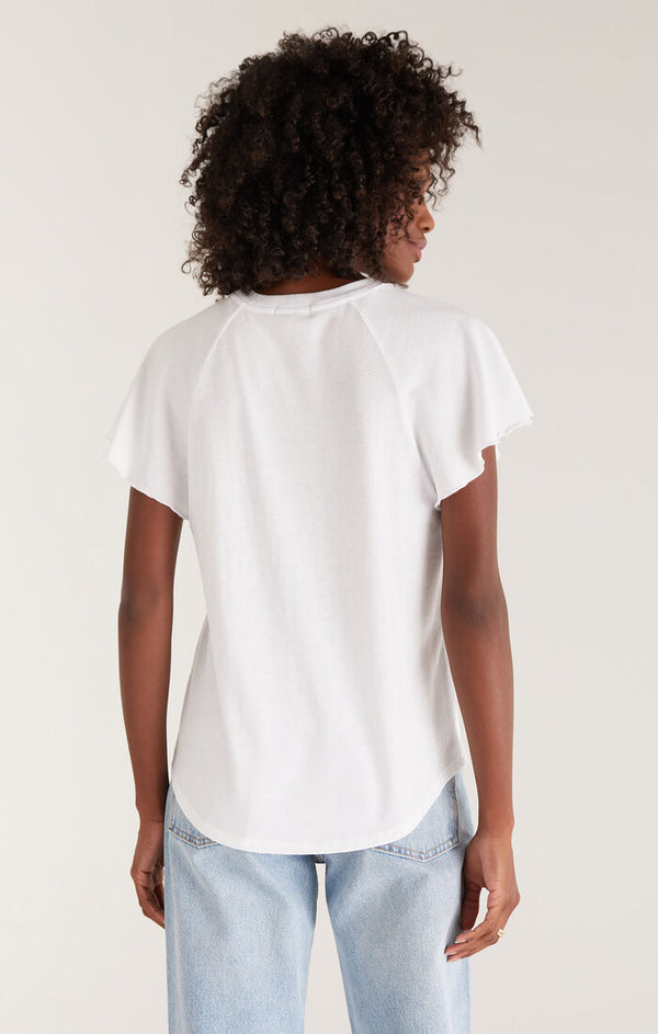 back view of the model wearing the abby flutter tee. shows the raglan seaming. also shows the flutter detail sleeves and the shirttail hem. 