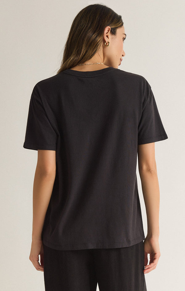 back view of the model wearing the under the palms tee. shows the oversized fit. also shows the short sleeves and crew neckline. 
