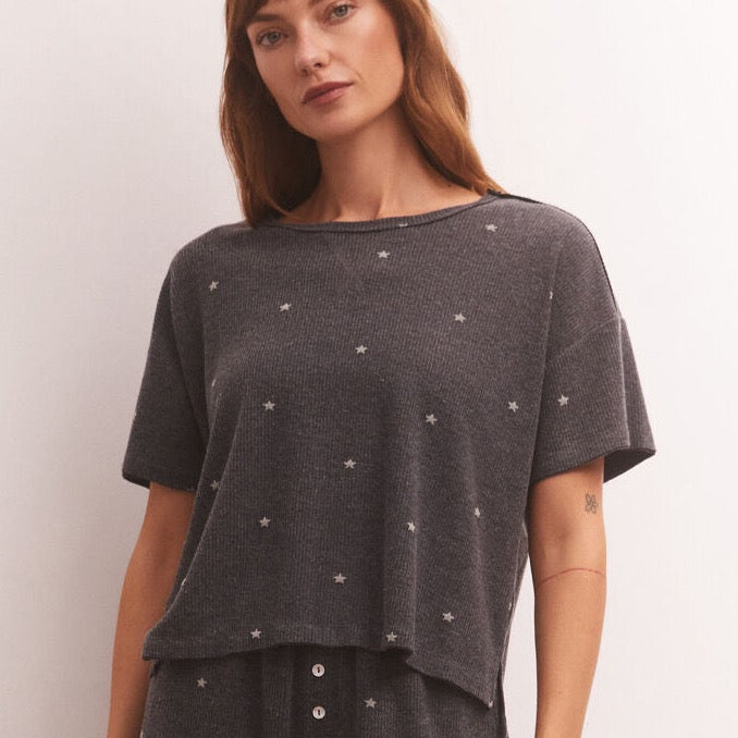 front view of model in shirt. shows the relaxed crew neckline, dropped shoulders, short sleeves, boxy fit and mini star print all over.