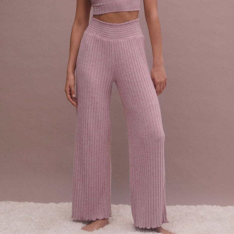 shows front view of model wearing the pants. shows the high smocked waistband, ribbed fabrication, and lettuce edge hem.
