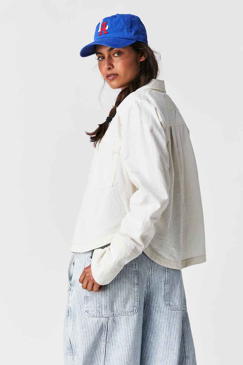 Side view of the model wearing the classic Oxford. Shows the defined hemming. Also shows the round bottom hem and the front patch hem. 