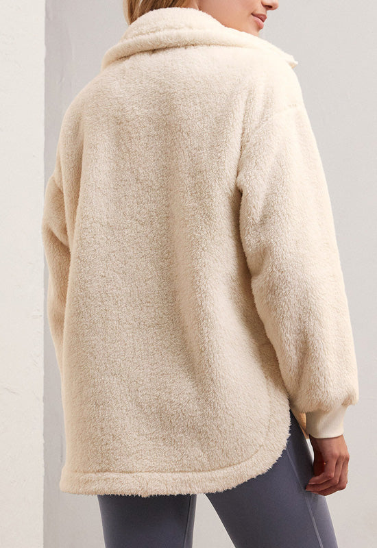 back view of model wearing highest peak jacket in sandstone. shows the oversized collar. also shows the step hem, the side vents and the oversized fit. 