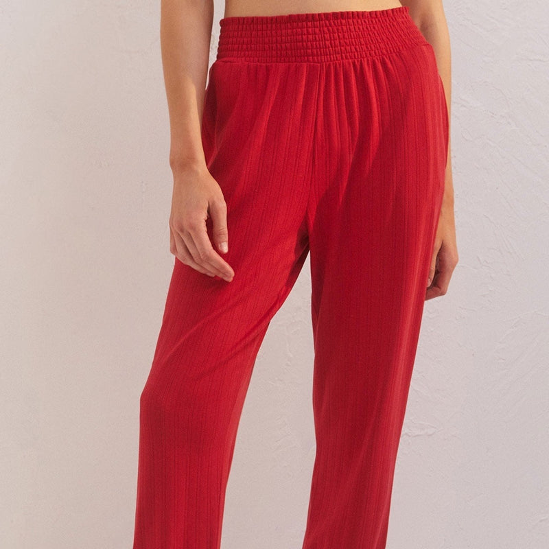 front view of holly pointelle joggers in red. shows the smocked waistband that is elastic. also shows slit ruffle by the waistband and the ribbed detail throughout the jogger.