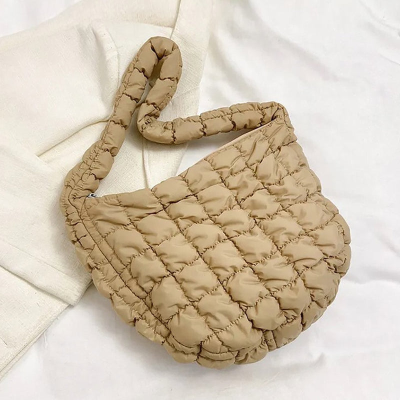 Front view of tote bag. Shows the puffer detail, the one shoulder strap and the beige color. 