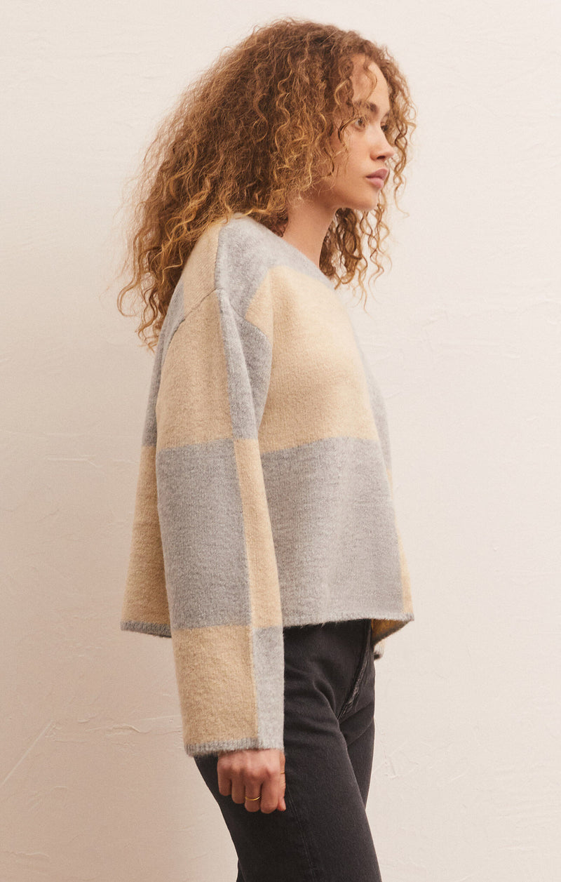 side view of model in sweater. shows the dropped shoulders, wide sleeves, and boxy fit.